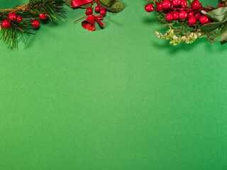 Vibrant green background with festive Christmas decorations, including red berries, pine branches, and bells. Ideal for holiday greetings.