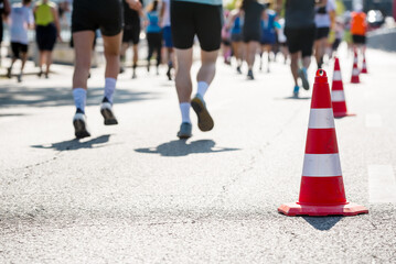 Traffic cone against defocused legs of running people