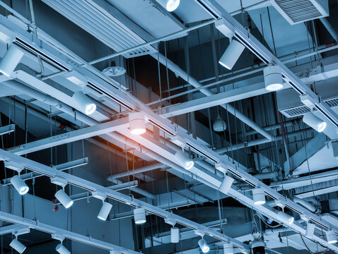 Directional LED lights on rails under the ceiling in a modern warehouse, shopping center building, office or other commercial real estate object.