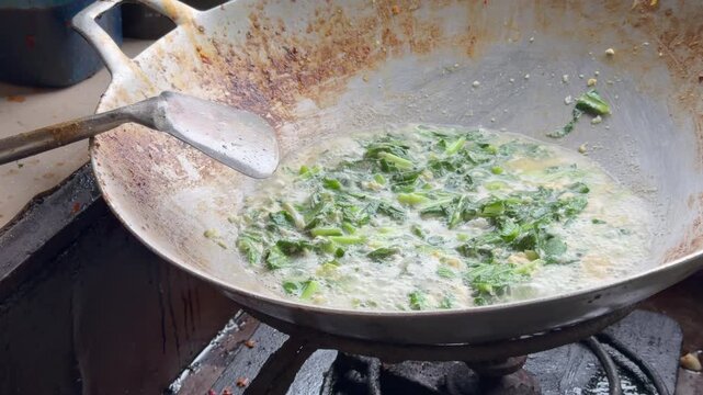 Close up process of cooking flat rice noodles with vegetables and egg in a traditional wok