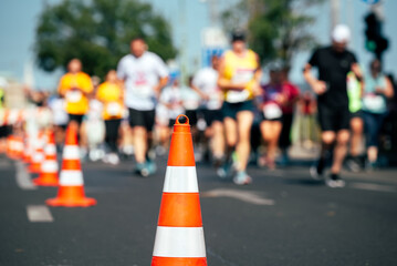Road cone against many people running