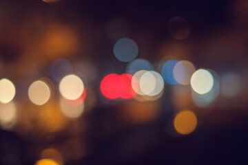 Bright circular bokeh lights against a deep dark night sky. A vibrant, blurry and modern city background. Deliberately out of focus. Perfect for abstract design.