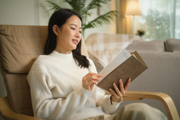 Relaxed young woman enjoying a quiet moment at home while reading a book.