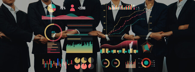 A group of professionals stands together in formal attire, analyzing data through engaging charts and graphs, showcasing collaboration and data-driven approaches in business. Axiom