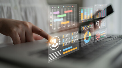A focused individual interacts with a laptop, utilizing advanced digital analytics and visual data tools to enhance business performance and insights. Gantry