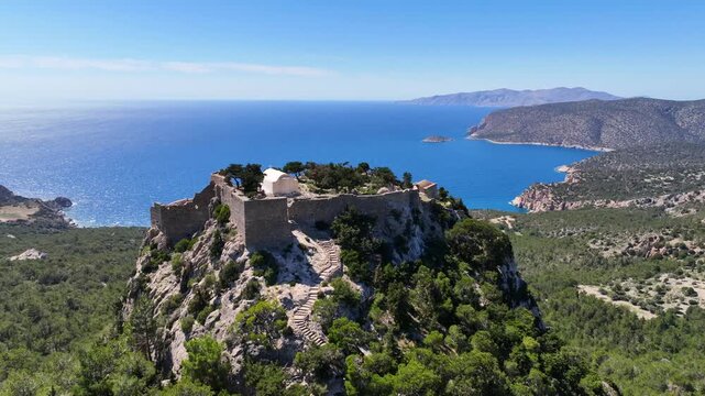 Aerial drone cinematic video of 15th-century Castle of Monolithos built on a cliff with picturesque views of the Aegean sea, Rhodes island, Dodecanese, Greece