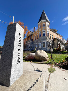 Derby Line, VT - USA: The Haskell Free Library sitting on the international border between USA and Canada showing library and USA granite border obelisk 