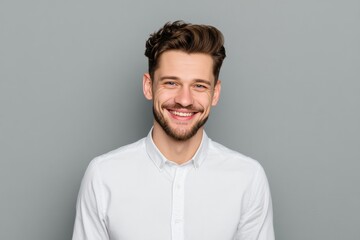 Obraz premium Cheerful young businessman smiles confidently in studio portrait against neutral background