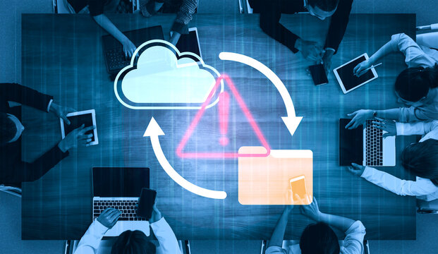 A diverse business team engages in digital collaboration, utilizing technology tools while being mindful of cloud computing risks during their workspace meeting. Gantry - Powered by Adobe