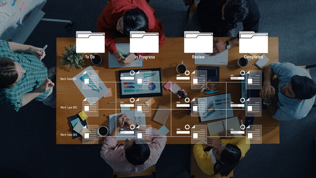 A dynamic overhead view of a collaborative office space showcasing a task management board with team members working on project planning and organization actively. Trope - Powered by Adobe