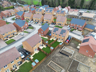 Interesting drone UAV inspection view of newly built homes seen on a sprawling housing development in Britain. Part finished homes can also be seen. Homeowners have moved in.