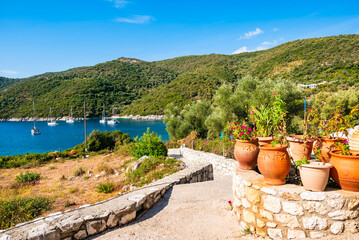 Flower pots along path to beautiful Mikros Gialos bay, Lefkada island, Greece