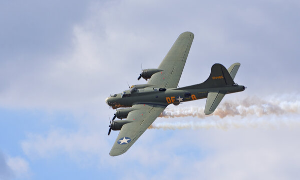 Vintage  B-17 Flying Fortress G-BEDF Sally B with smake and cloudy flight sky.