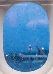 window of an airplane on a rainy day