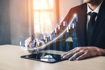 A businessman engaged in analyzing financial data with a tablet, surrounded by modern office elements and digital graphs illustrating growth trends and statistics. Impute