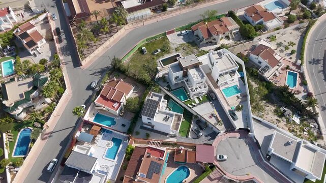 Spinning aerial view of residential neighborhood with villas and swimming pools