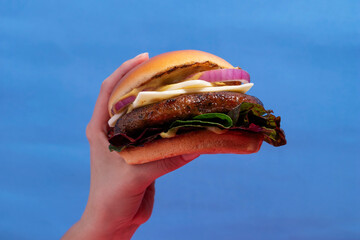 Artisanal Cheeseburger with Brioche Bun in Hand