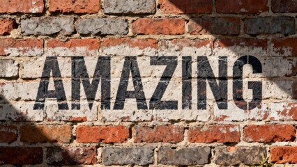 Motivational word AMAZING spray painted in black stencil letters over white paint on an old weathered exterior brick wall surface.