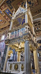 Rome, Italy &ndash; 14 January 2025. The Gothic ciborium in San Giovanni in Laterano rises above the altar with gold detailing, blue starry canopy, frescoed apostles, spires, and grey columns beneath a carv