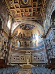 Rome, Italy &ndash; 14 January 2025. The apse of San Giovanni in Laterano features a golden mosaic of Christ with saints, a white papal throne below, and a richly coffered ceiling with dark blue and gold