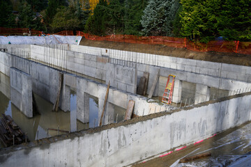 After the storm, under construction stormwater tank flooded with rainwater, foundation dug and concrete poured
