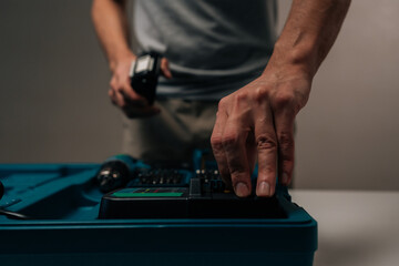 Cropped shot of handyman hands handling component from open power drill toolkit, preparing for work on diy project, construction, professional repair, showcasing tools and equipment.
