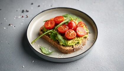 minimalist avocado toast with cherry tomatoes and greens on speckled plate showcasing fresh ingredients and vibrant colors