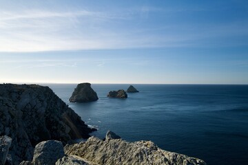 Rugged rocky coastline with sea stacks under a clear blue sky