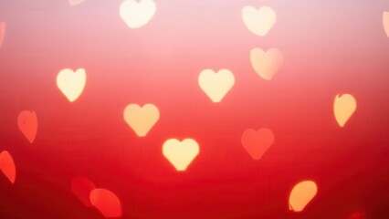 Heart shaped bokeh lights creating a romantic and warm red background atmosphere
