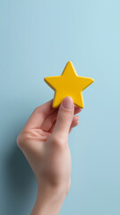 A hand holding a yellow star shape against a blue background symbolizing rating, quality and achievement.

