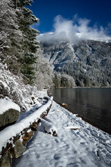 Chilliwack lake beach covered in fresh snow on sunny winter day 