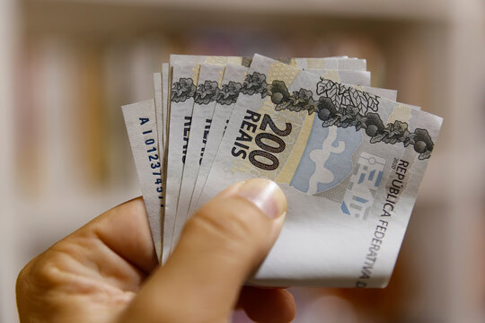Hand holding folded two hundred reais banknotes close-up