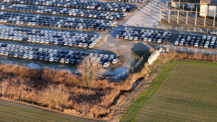 Huge lot full of brand new cars displaying mass production and the extensive logistics required for...