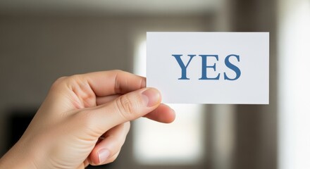 Hand Holding a Card with the Word 'YES' Displayed Positively, Representing Agreement and Confirmation