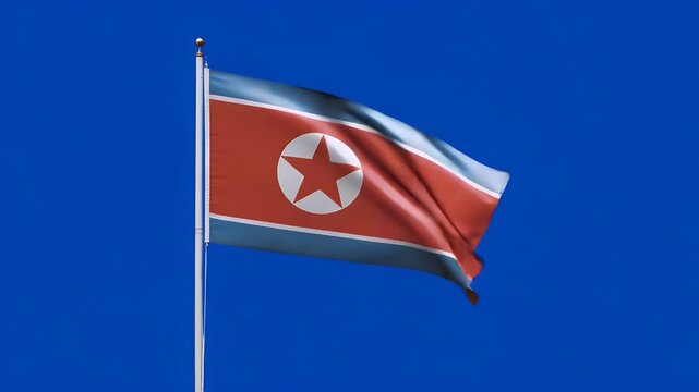 North Korean flag waving gracefully against a vibrant blue sky in a patriotic display of national identity and pride
