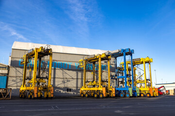 Gantry cranes stand ready to load and unload cargo containers at a shipping port. These machines are essential for efficient global trade.
