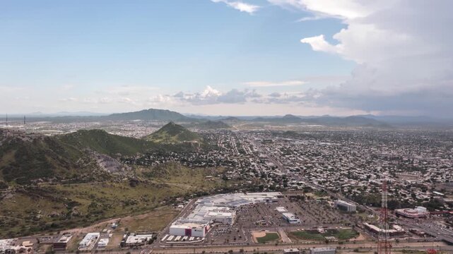 Aerial panoramic hyperlapse over Hermosillo, Sonora, as the drone flies sideways, revealing the city layout, surrounding hills, and expansive urban landscape under clear skies.