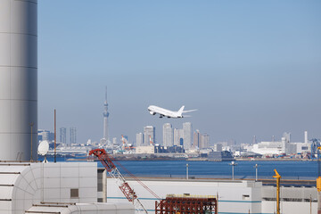 羽田空港、第一ターミナルから見た第二ターミナル超しに見える離陸する旅客機