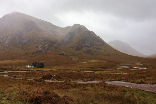 Lagangarbh Cottage &ldquo;Wee White House&rdquo; beneath Buachaille Etive M&ograve;r in River Coupall landscape scene; charming Scottish Highlands hut beside flowing river, autumn mountain backdrop in Glencoe, Scotland