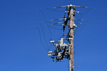 Old telephone pole completely retrofitted with new strain insulators, radio controlled dropout fuses, jumper cables and electrical lines 