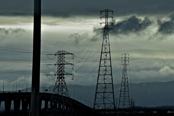 Silhouette of Utility poles next to Dumbarton Bridge, San Francisco Bay, California 