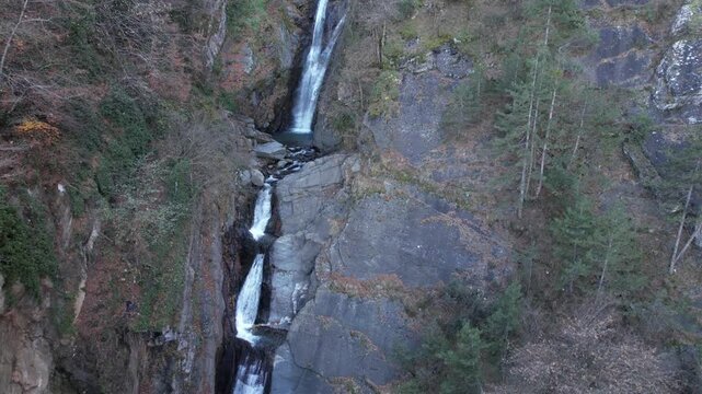 Drone Pull Back from Waterfall in Mountain Forest