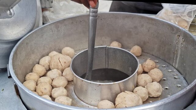 Steaming hot soup and meatballs or Bakso sold by a street vendor