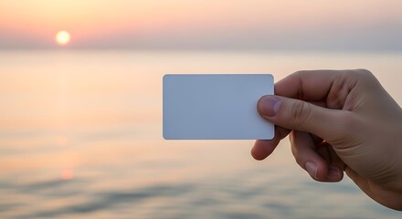 Blank Card Held Against a Sunset Ocean Backdrop.