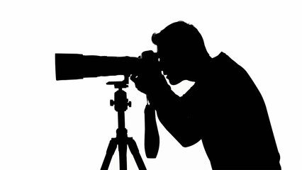 Silhouette of a photographer taking a picture with a large lens camera on a tripod.