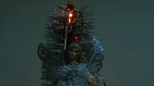 A Christmas tree complete with a glowing angel with silver wings
