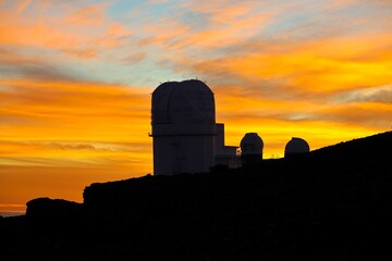 The sun sets above the clouds at the summit of the Haleakala volcano on Maui