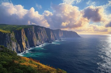 Sunlit rugged sea cliffs with turquoise waters, grassy wildflower foreground and dramatic golden clouds on the horizon, evoking awe and serene coastal majesty