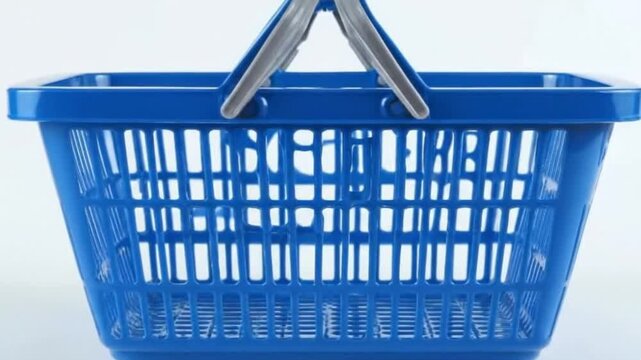 This studio-shot video features a vibrant, empty blue plastic shopping basket presented against a clean white background. The simple yet striking composition highlights the basket's sturdy constructio