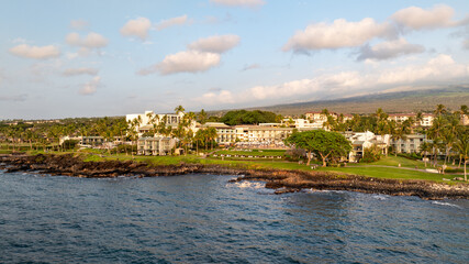 Obraz premium Panoramic aerial view of beachfront resorts, and vacation homes along coastal landscape in Wailea-Makena Maui Hawaii during golden hour sunset